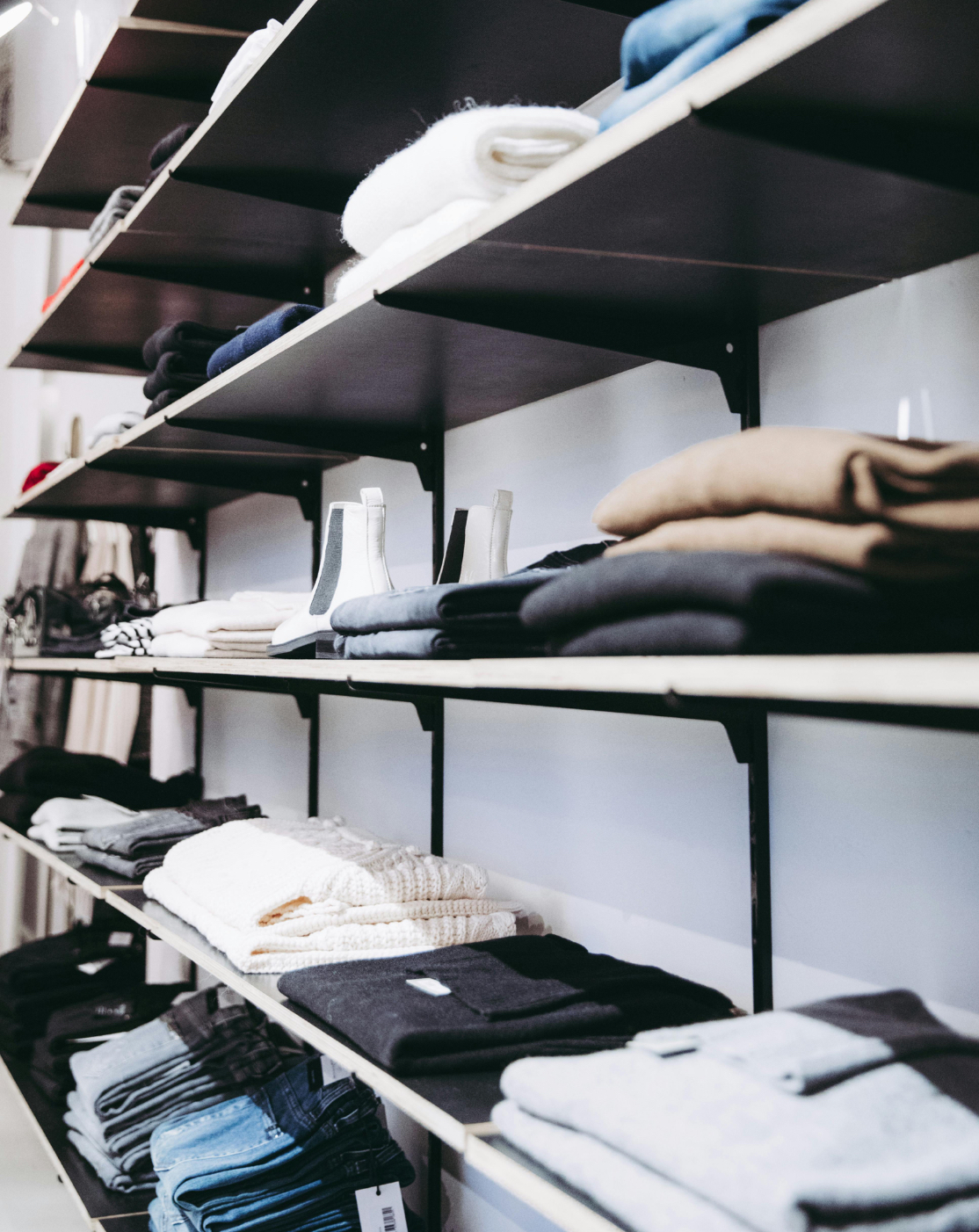 A clothing store interior featuring various garments displayed on racks
